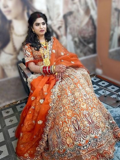 A beautiful bride in an orange lehenga, ready for her big day. I created a soft glam makeup look with defined eyes and a hairstyle with gentle waves.