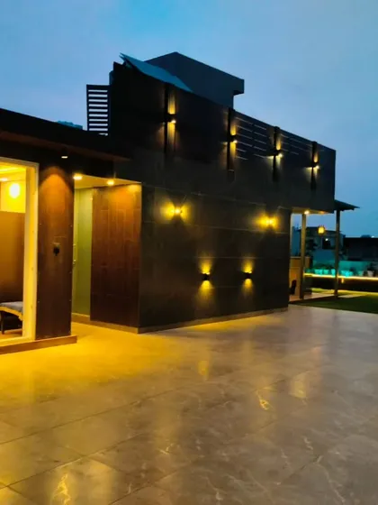 A completed office cabin on a rooftop in Sushant Lok, Gurgaon. The warm interior lighting contrasts with the modern, dark exterior cladding.