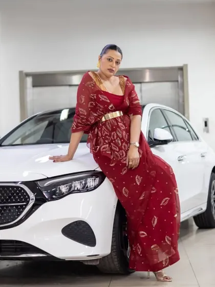 Posing with the new Mercedes E-Class. This stunning red saree by Ravi Bajaj, with its delicate gold embroidery, perfectly complements the luxury and class of the car.