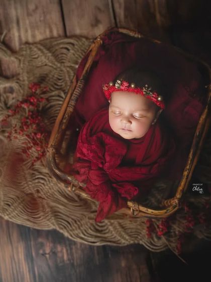 An aerial view of this rustic red setup, with the baby nestled in a basket. This angle highlights the textures of the wood floor and woven blankets.