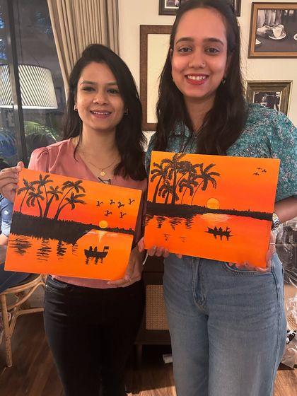 Two more smiling artists showing off their tropical sunset scenes. Each one has a unique touch.
