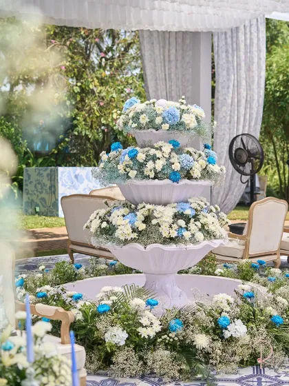 The centerpiece of the carnival: a three-tiered white fountain overflowing with white, blue, and light green flowers. This custom installation was a major focal point.