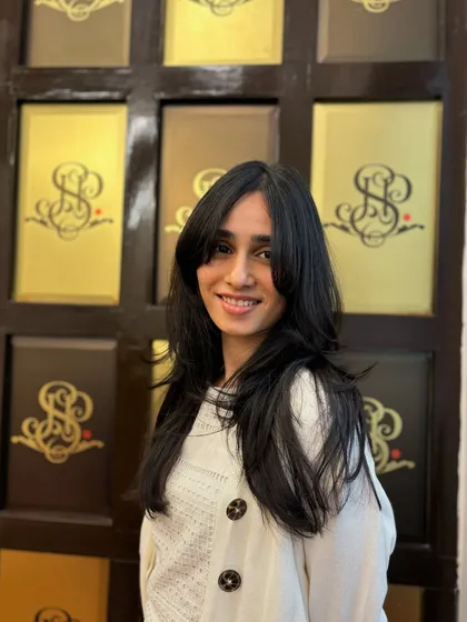 A great haircut frames your face beautifully. This look features soft, face-framing layers and bangs that add dimension and highlight her features perfectly.