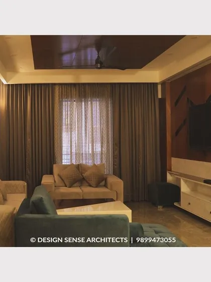 A full view of a living room where we balanced a dark wood TV panel and brown curtains with a light-colored sofa set, creating a warm and balanced aesthetic.