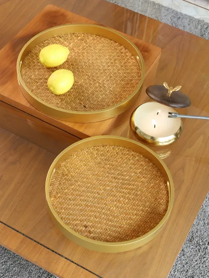 The round woven trays, styled with lemons and a candle. This showcases their versatility as a decorative base, bringing a touch of rustic charm to any setting.