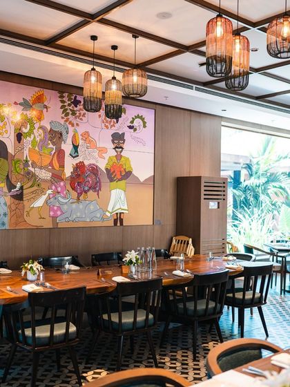 The interior of our Terra restaurant, featuring a large, vibrant mural that reflects the local culture and our connection to the land. The long wooden table is perfect for communal dining.