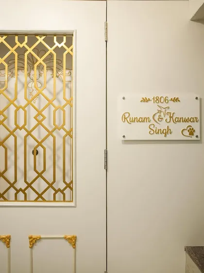 A close-up of the custom acrylic nameplate, designed to match the white and gold theme of the entrance.