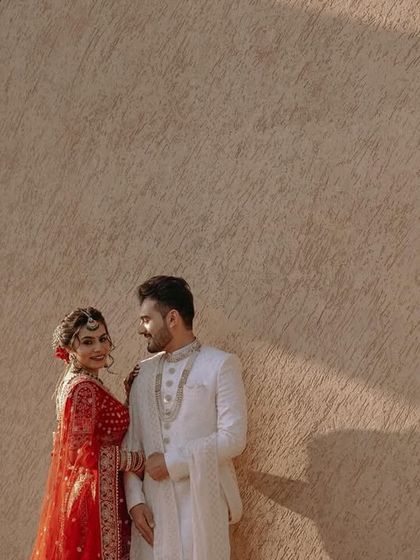 A stylish portrait of the couple against a textured wall, the sunlight highlighting their features.