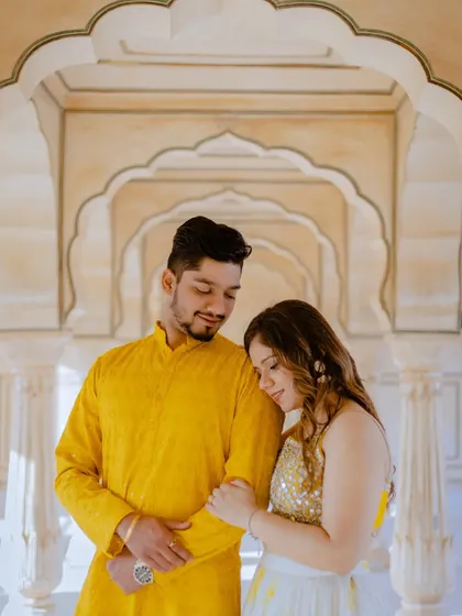 A sweet, intimate moment captured in the beautiful corridors of a Jaipur fort. The soft light and warm tones of the stone create a romantic and timeless feel.