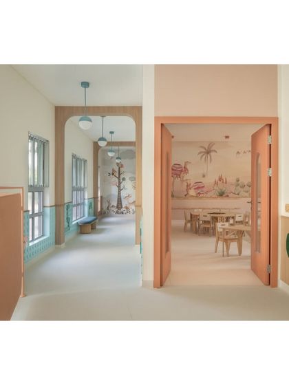 A view from the corridor into one of the desert-themed classrooms, showing the seamless transition between spaces. The warm color palette and playful details create a welcoming atmosphere from the moment you approach the room.