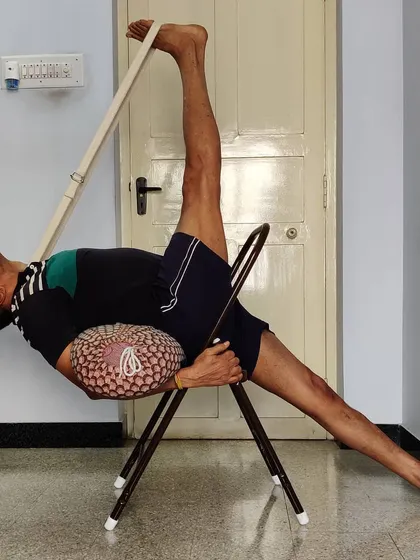 Eka Pada Urdhva Dhanurasana (One-Legged Upward Bow Pose) with a chair, bolster, and belt. This shows how multiple props can be used to safely explore very advanced backbends.