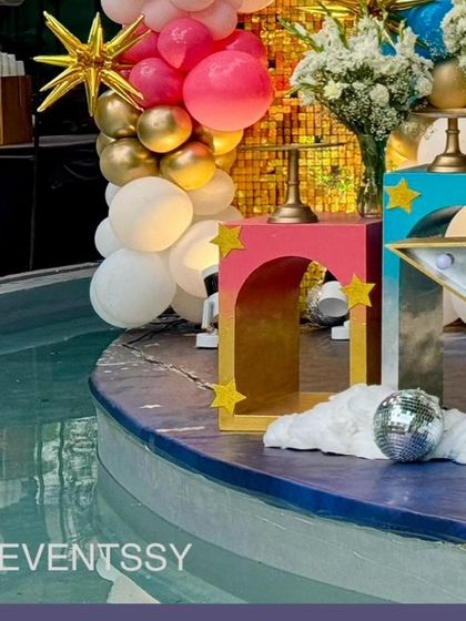 A poolside detail, showing the colorful pedestals and a mini disco ball reflecting on the water.