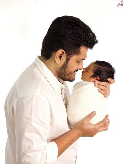 A tender moment between father and son, captured against a clean white background for a classic, timeless feel.