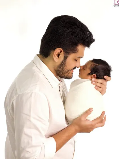 A tender moment between father and son, captured against a clean white background for a classic, timeless feel.