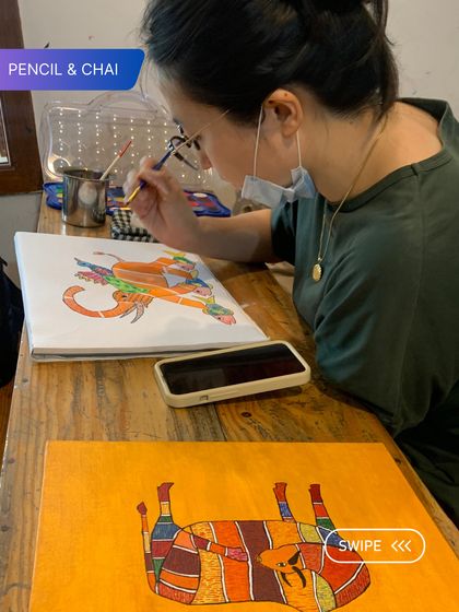 A student works on a Gond painting, using a reference from her phone. This blend of traditional art and modern tools is a common sight in our studio.