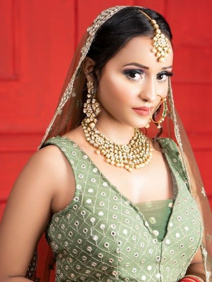 This client looks lovely in a light green lehenga with mirror work, perfect for a Mehendi or Haldi ceremony. The pearl Kundan jewellery set adds a touch of elegance.