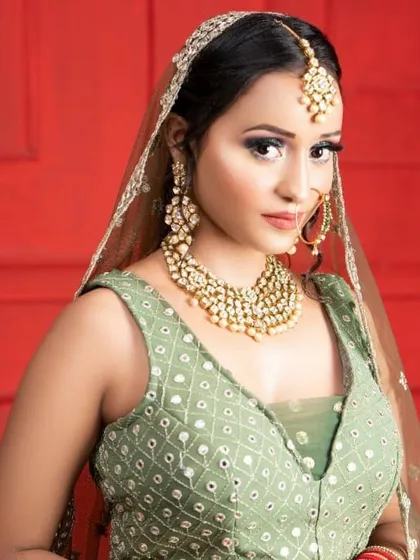 This client looks lovely in a light green lehenga with mirror work, perfect for a Mehendi or Haldi ceremony. The pearl Kundan jewellery set adds a touch of elegance.