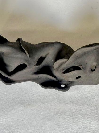 This abstract sculpture was created by hand, exploring organic forms and movement. It's a piece that invites you to look closer and find your own meaning.