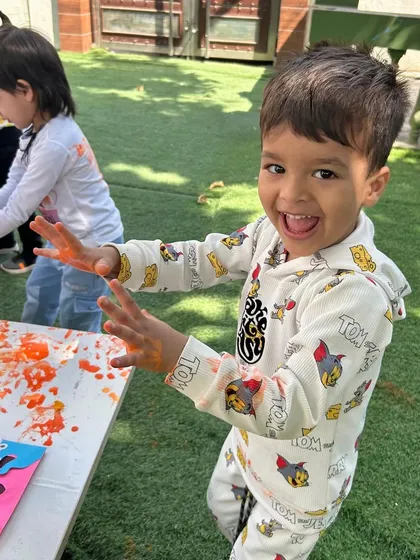 Pure, unadulterated joy. This little boy's expression says it all as he shows off his colourful hands during our fun and safe Holi party in the garden.