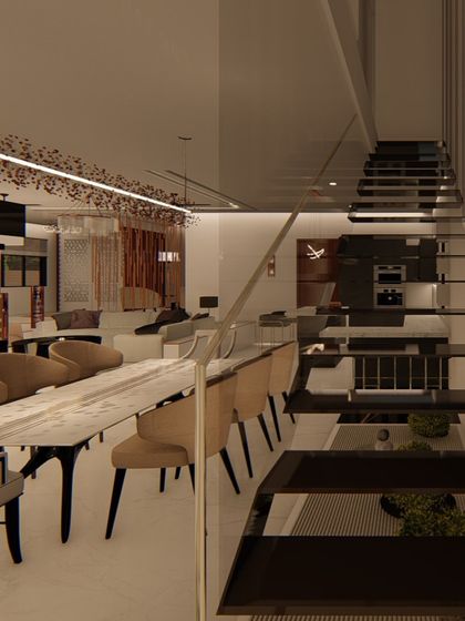 A view of the dining area from the staircase, showing the long marble table and the open, airy feel of the double-height space. This perspective highlights the home's grand scale and interconnected design.
