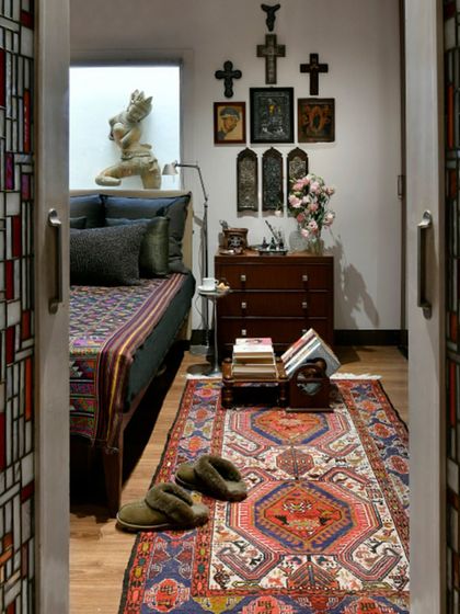 A view into the bedroom through stained glass doors inspired by Frank Lloyd Wright. This detail adds an architectural element and a layer of privacy, while hinting at the personal and curated space within.