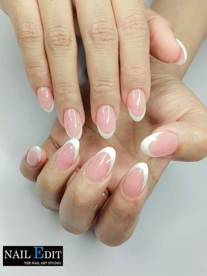 The timeless classic. This is our perfectly executed traditional French manicure on clean, almond-shaped nails, featuring a natural pink base and crisp white tips for a look of simple elegance.
