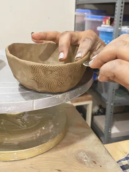 Carving textures into a hand-built bowl. This is a great way to personalize your creation before it gets fired.