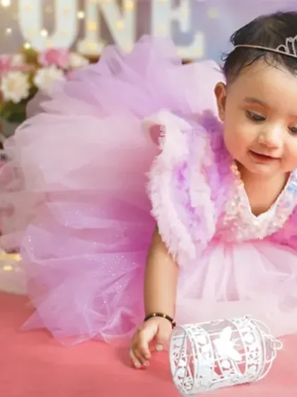 A little princess exploring her birthday setup. The tiara and fluffy dress make this first birthday shoot feel like a fairytale.