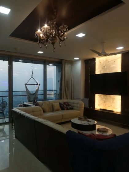 Another angle of the Goregaon living room, showing the stunning city view from the large windows and the cozy indoor swing, perfect for enjoying a cup of tea.