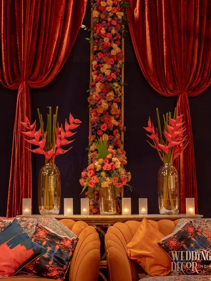 A detail shot of the floral arrangements and candles behind the lounge sofas, adding depth and beauty to the backdrop.