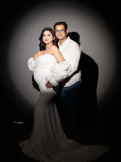 I love playing with light to create different moods. This dramatic spotlight technique creates a timeless, intimate portrait that beautifully highlights the couple and the baby bump, making it a powerful piece of art for your home.