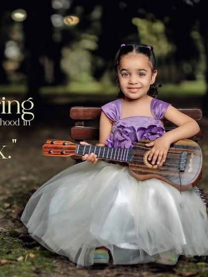 Capturing the essence of childhood in every click. An older girl plays the ukulele on a park bench.