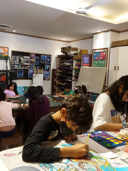 The Saturday class is a time for deep focus. This student is completely absorbed in his painting, surrounded by the inspiring art on the studio walls.