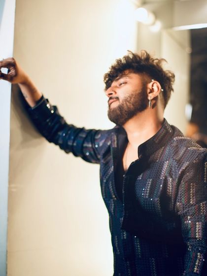 This profile shot highlights the texture and pattern of the sequined jacket. It's a statement piece that's both stylish and masculine.