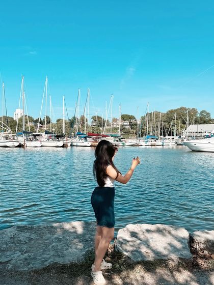 A beautiful summer day at a marina in Ontario. This image, with sailboats in the background, evokes a classic summer aesthetic perfect for fashion or lifestyle brands.