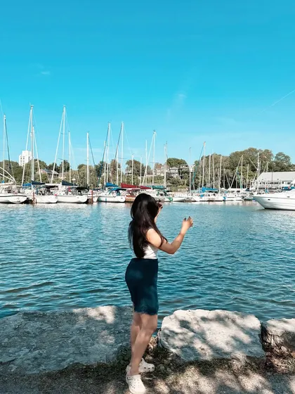A beautiful summer day at a marina in Ontario. This image, with sailboats in the background, evokes a classic summer aesthetic perfect for fashion or lifestyle brands.