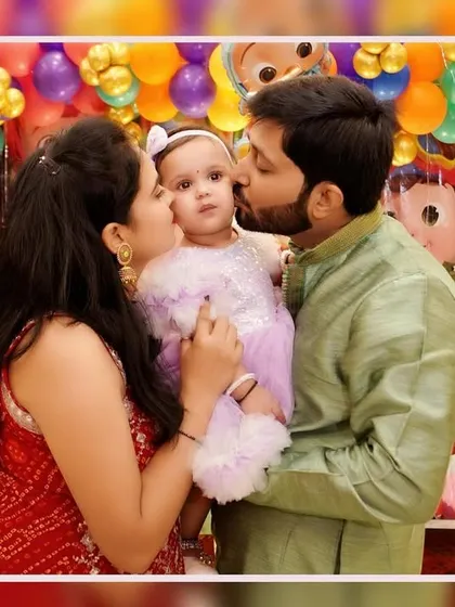 A baby's first birthday is a milestone for the whole family. We focus on capturing these loving, candid family portraits, like this tender kiss from mom and dad, creating a memory that will be cherished for a lifetime.