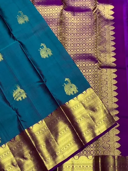Another view of the teal Kanchipuram silk saree, highlighting the contrast with the purple border.