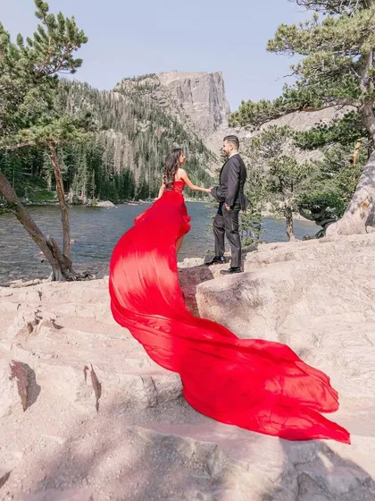 Create unforgettable memories with a pre-wedding photoshoot in one of my signature flying dresses. This couple chose a vibrant red trail gown, which creates a beautiful contrast against the natural mountain landscape.