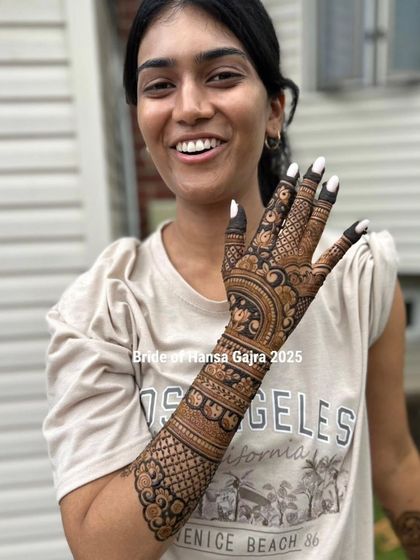 The smile on this bride's face says it all. Her back-of-hand mehendi is detailed and beautiful, a perfect accessory for her happy and relaxed vibe.