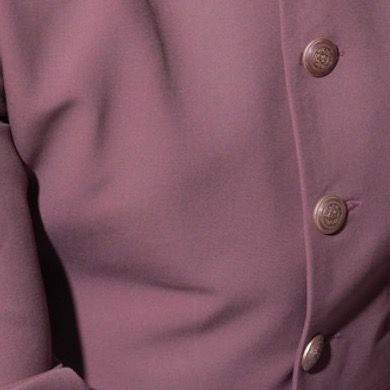 This close-up focuses on the custom buttons and smooth fabric of the pink Prince Coat. We select every component to ensure a cohesive and luxurious final garment.