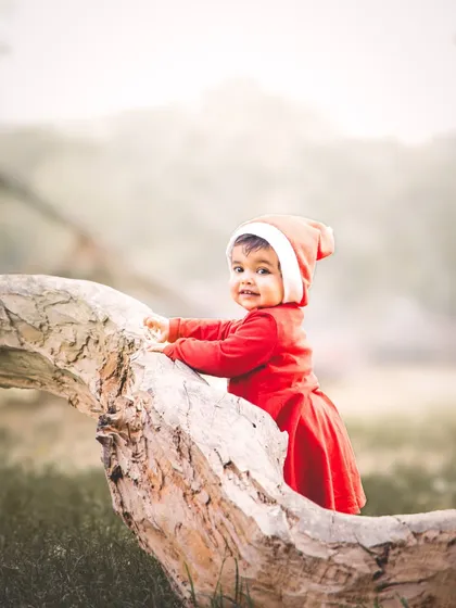 An outdoor-style portrait created with AI. This little one in her Santa hat looks like she's exploring a winter wonderland, a unique keepsake from our Christmas sessions.