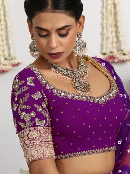 A detailed shot of the embroidered blouse, showcasing the fine craftsmanship and luxurious materials.