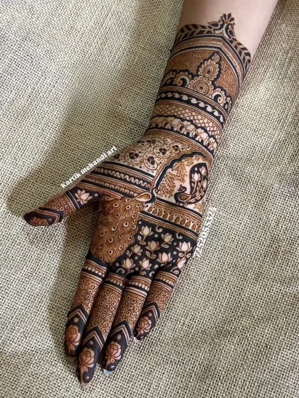 A classic Indian traditional design featuring a peacock on the palm and an elephant on the wrist, surrounded by delicate floral and leaf patterns.