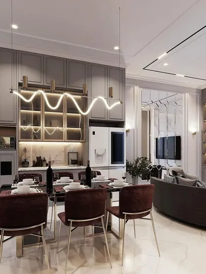 This open-plan living and dining area showcases our integrated design approach. We crafted the modern dining set with plush chairs and a sleek table, complemented by a custom crockery unit with fluted glass and built-in lighting to display prized possessions.