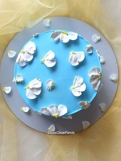 A simple and pretty cake with a sky-blue buttercream base and delicate, hand-piped white flower petals. This was a White Forest cake.