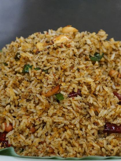 Our flavourful rice preparations are a cornerstone of our menu. This dish, served on a banana leaf, showcases the texture and aroma of our cooking, a perfect main course for any feast.