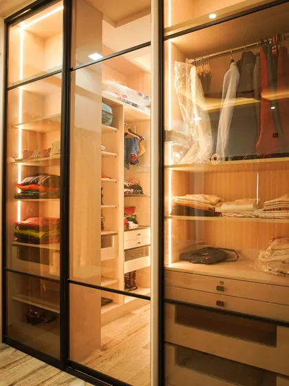 A walk-in wardrobe that combines luxury with organization. Featuring clear glass doors, custom shelving, and integrated LED lighting, this space turns daily routines into a boutique experience, keeping everything visible and beautifully displayed.