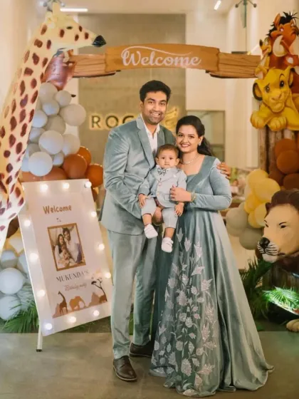 A family stands at the entrance of a jungle-themed mundan ceremony and party. We capture the grand decor and the welcoming moments of your event.