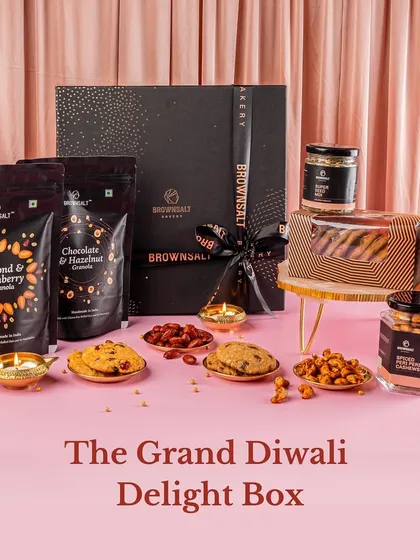 A full view of The Grand Diwali Delight Box. This hamper is a feast for the eyes and the palate, featuring our Almond & Cranberry Granola, Chocolate & Hazelnut Granola, assorted cookies, and spiced nuts in a premium black gift box.